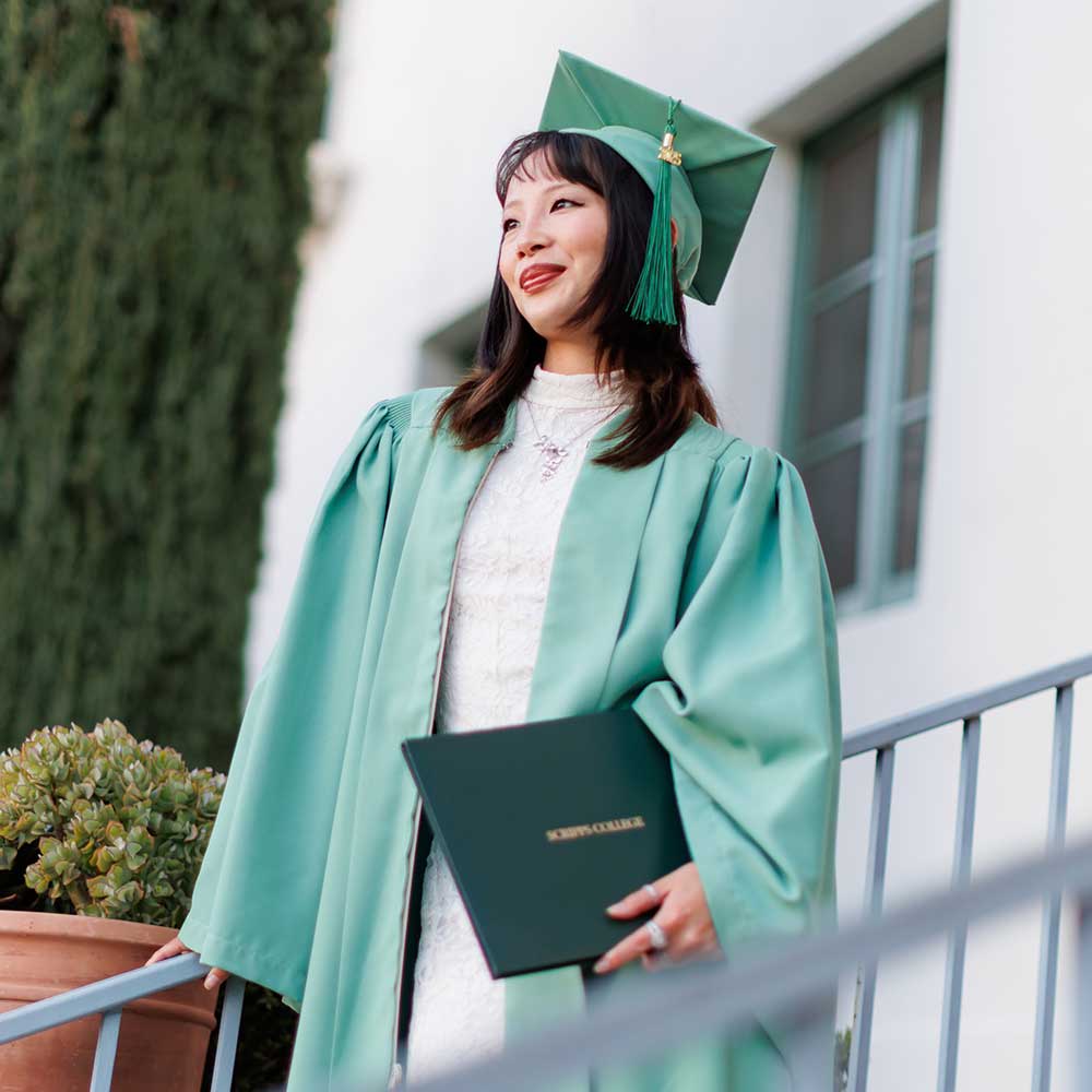 Student in cap and gown outside Balch Auditorium