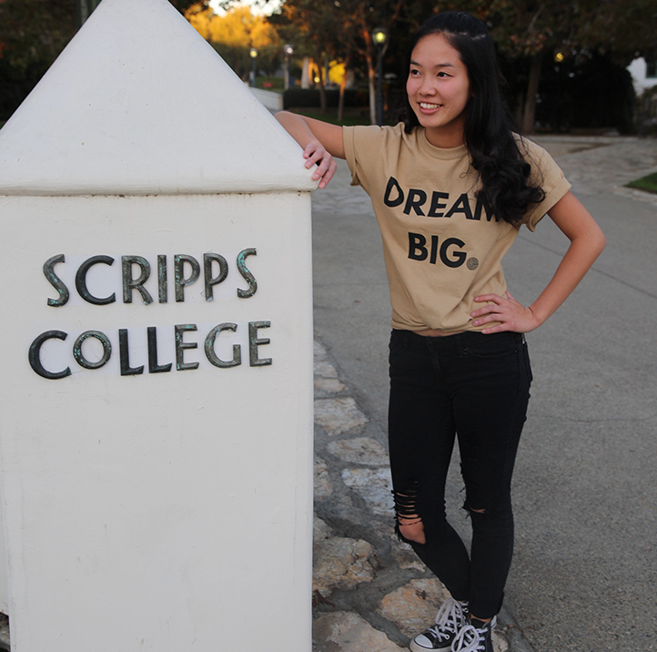 student standing by Scripps College sign