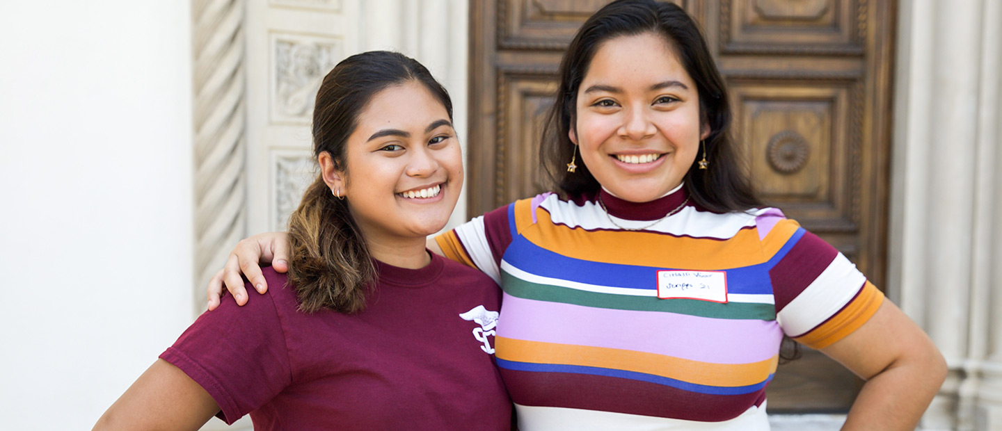 two scripps college academy students in front of denison library doors