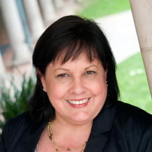 Woman smiling with black hair and black blazer