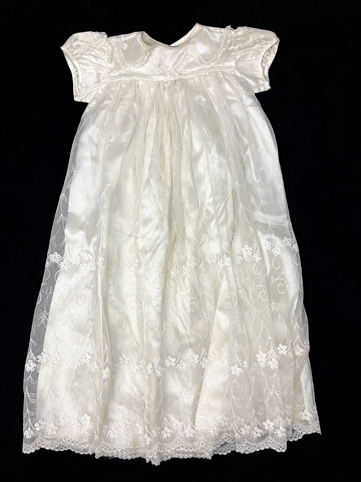 A white baby gown featuring Ayrshire needlework.