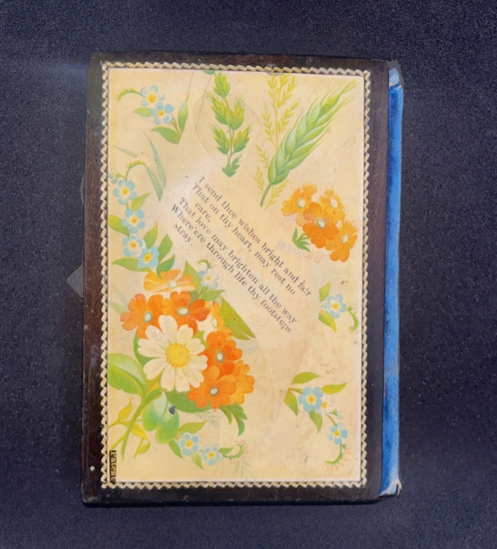 A black lacquer Mauchline ware needle book.