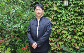 Professor Hao Huang strikes a pose among the leaves