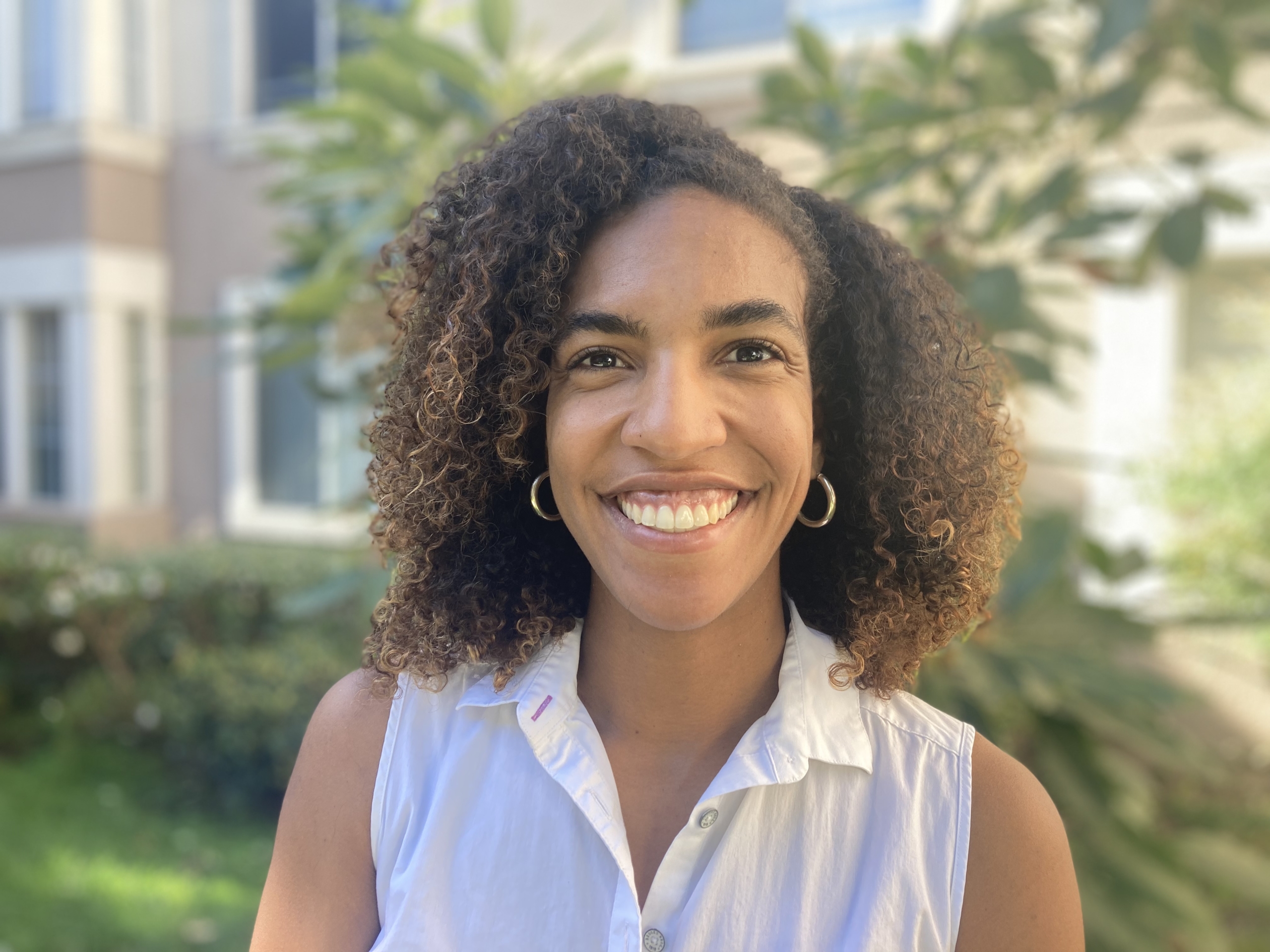 Black woman wearing a white shirt and with curly hair