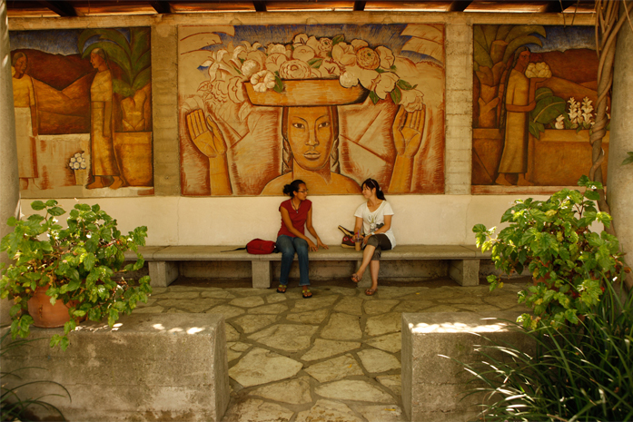 Two women sitting on a bench and talking in Margaret Fowler Garden.