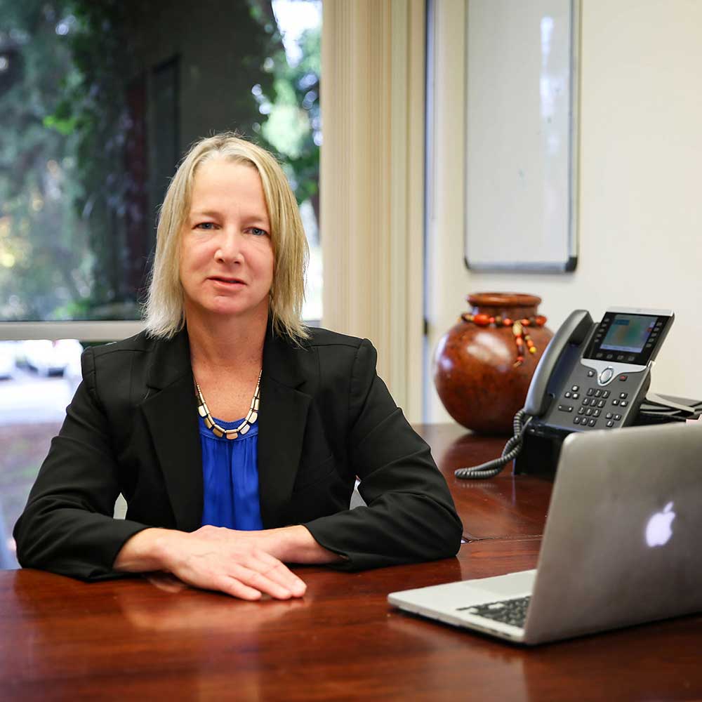 Prof. Stacey Wood at her desk with a laptop