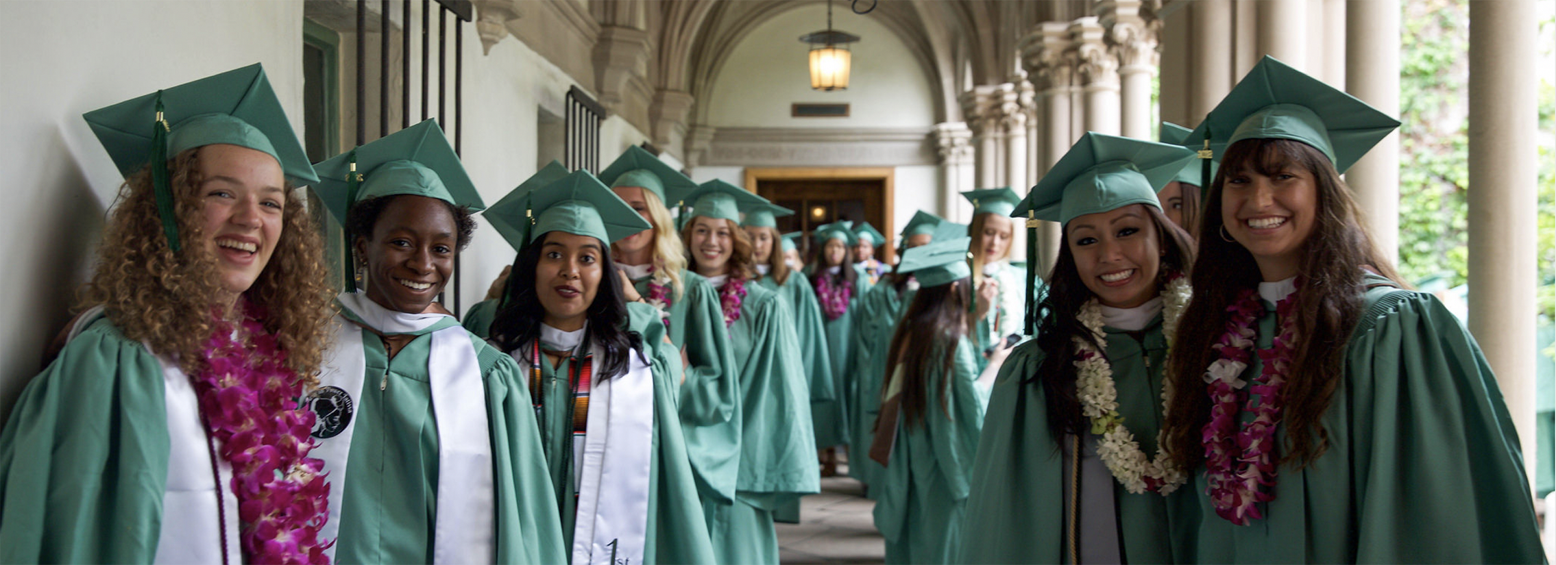 Scripps graduates in cap and gown smiling for a picture