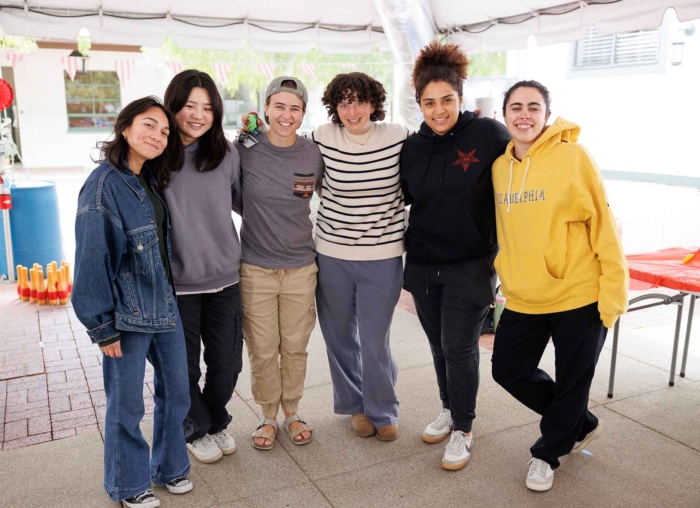 Six students smiling at a community event