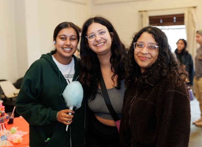 Three students smiling while holding cotton candy
