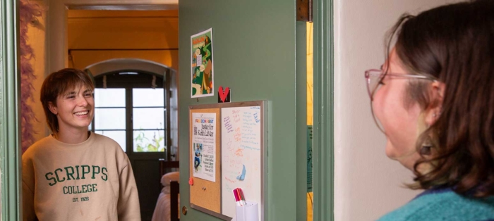 Scripps College students speaking to each other in the hallway