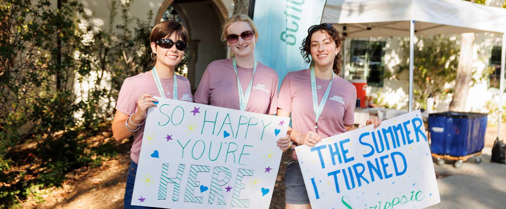 Scripps College students pose holding up welcome signs
