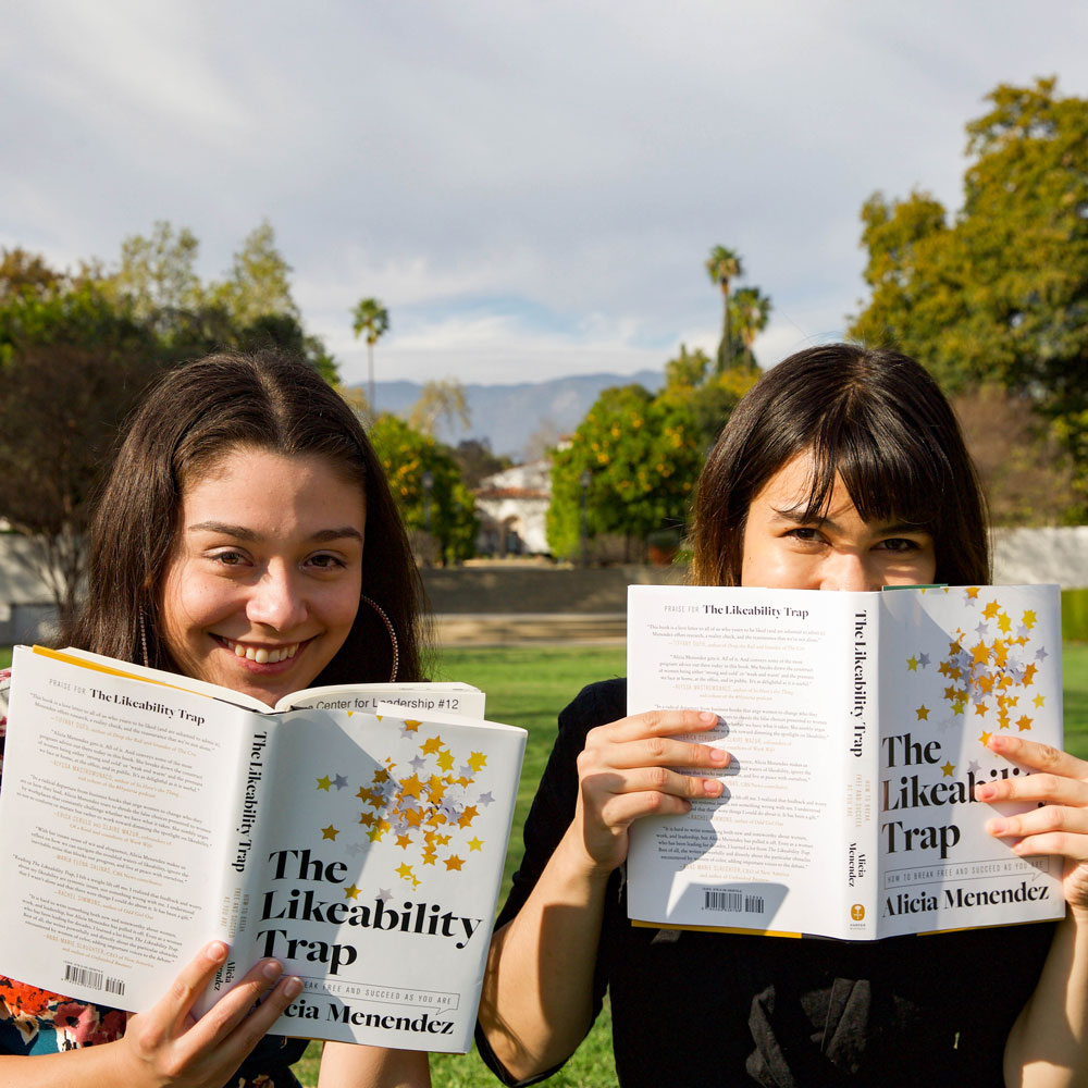 two students holding up books