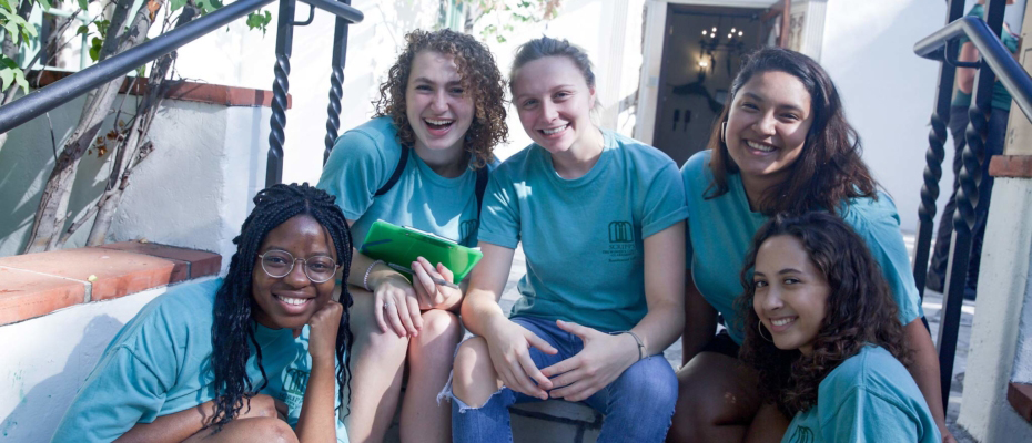 five scripps students smiling and sitting on staircase