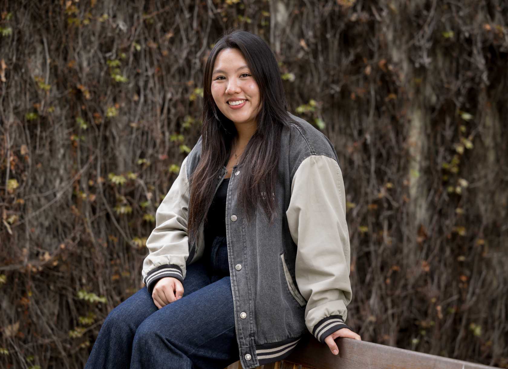 Abbie Oh Arroyo, a senior from the Class of 2025, sits on a bench