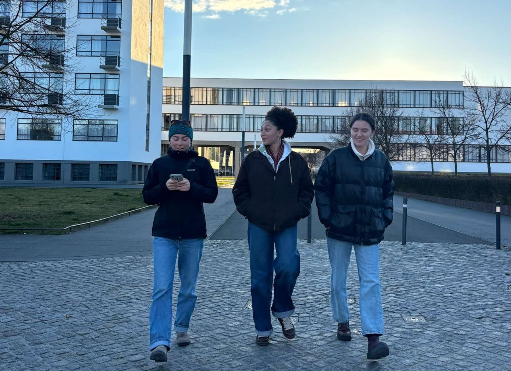 Scripps students wearing coats walk by Bauhaus buildings