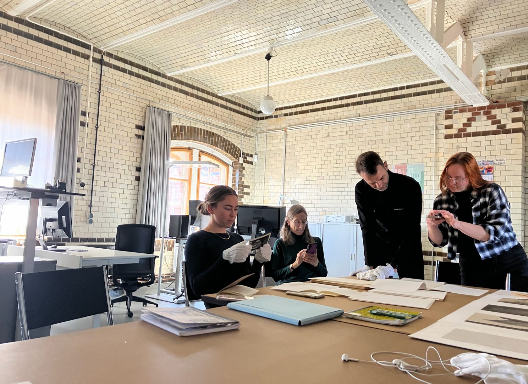 A student, wearing gloves, examines photos in the Bauhaus archives in Germany