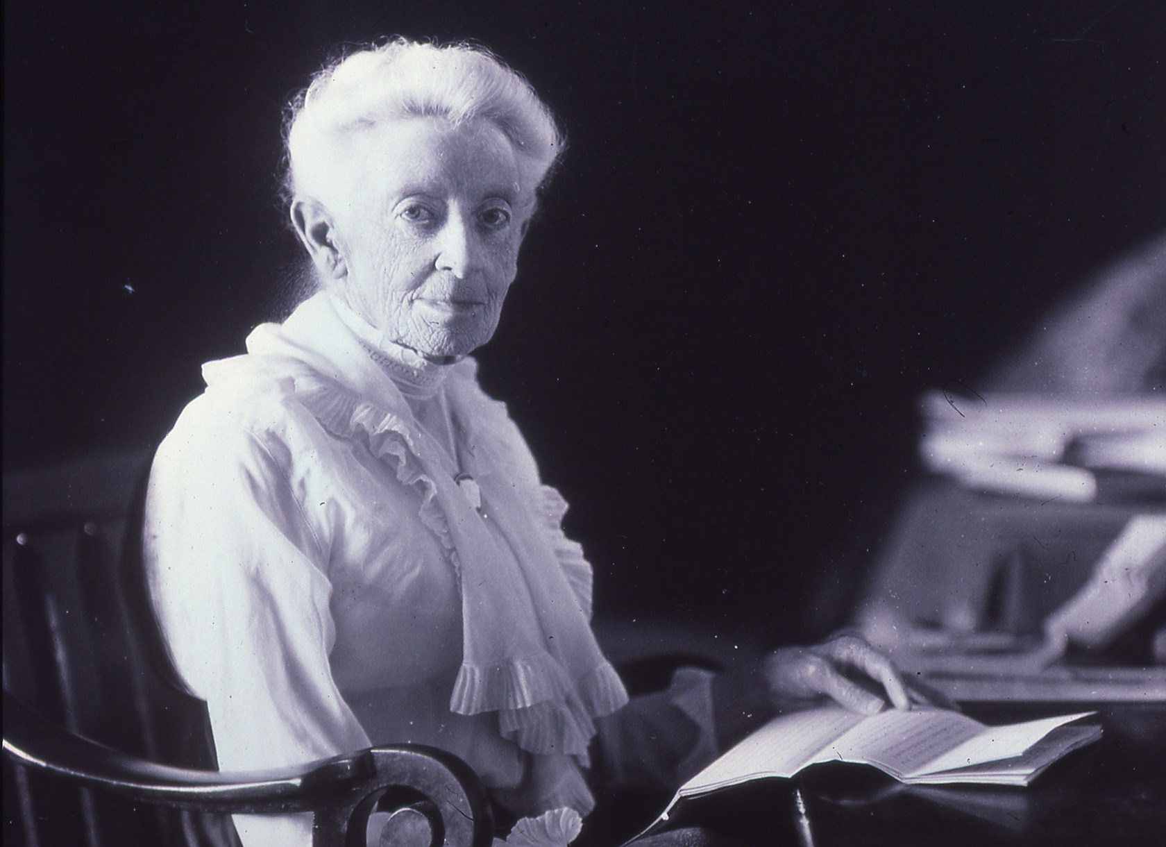 Portrait of elderly white woman sitting at desk