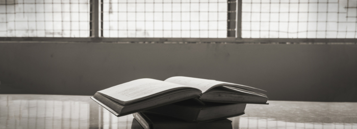 A black and white image of books on a table.