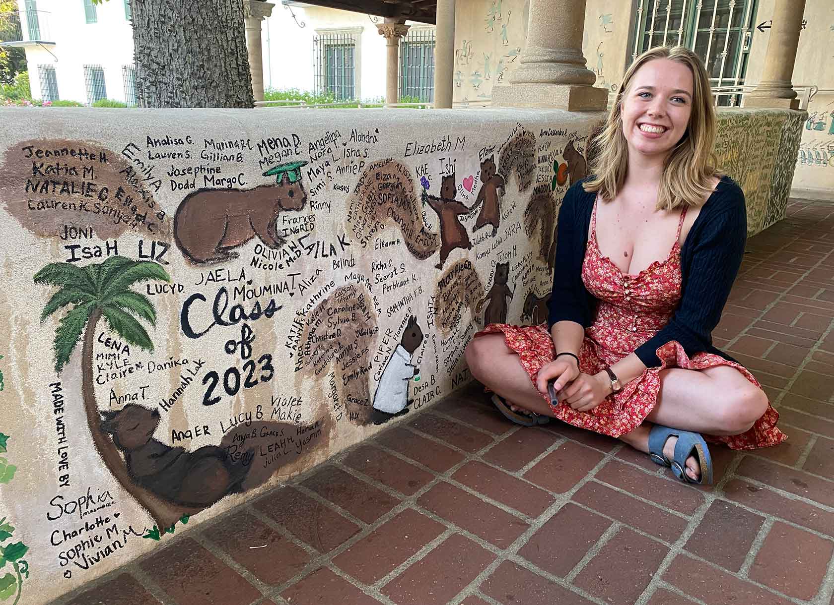 Sophia Frye '23 poses with her finished Graffiti Wall mural, representing the Scripps College Class of 2023