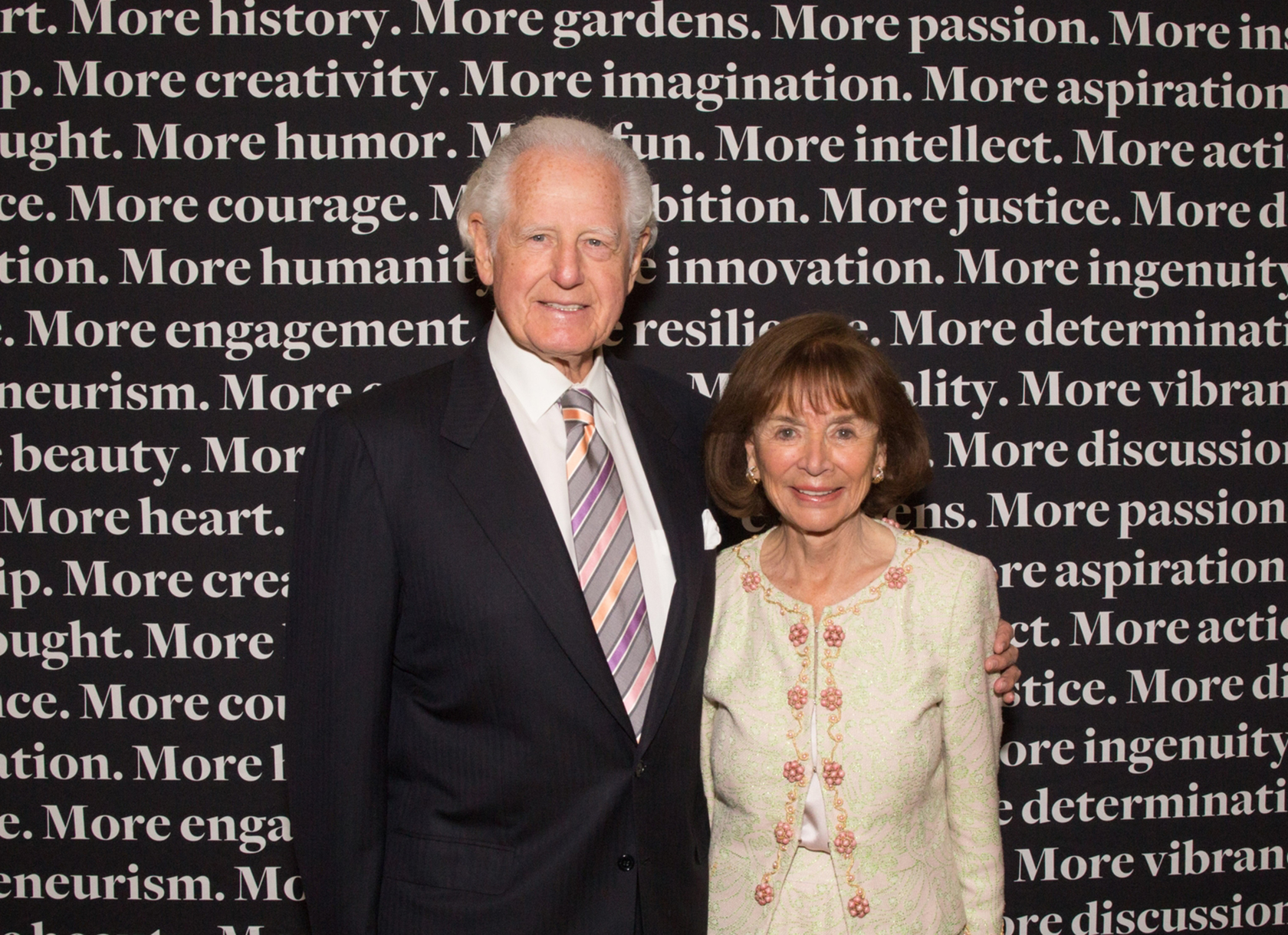 A white man and woman posing together in professional dress.