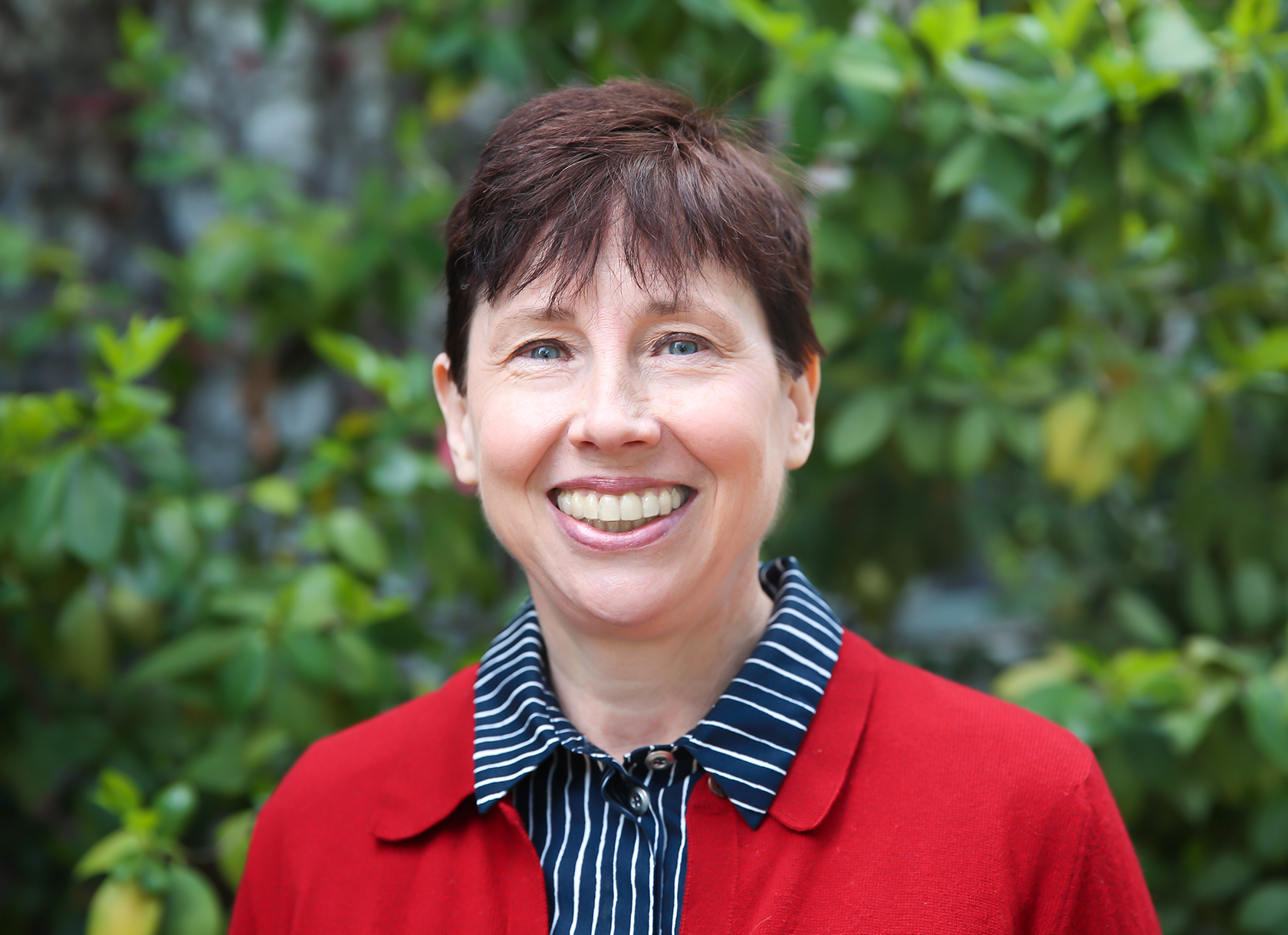 Close-up portrait of a White woman with short brown hair in a red blazer