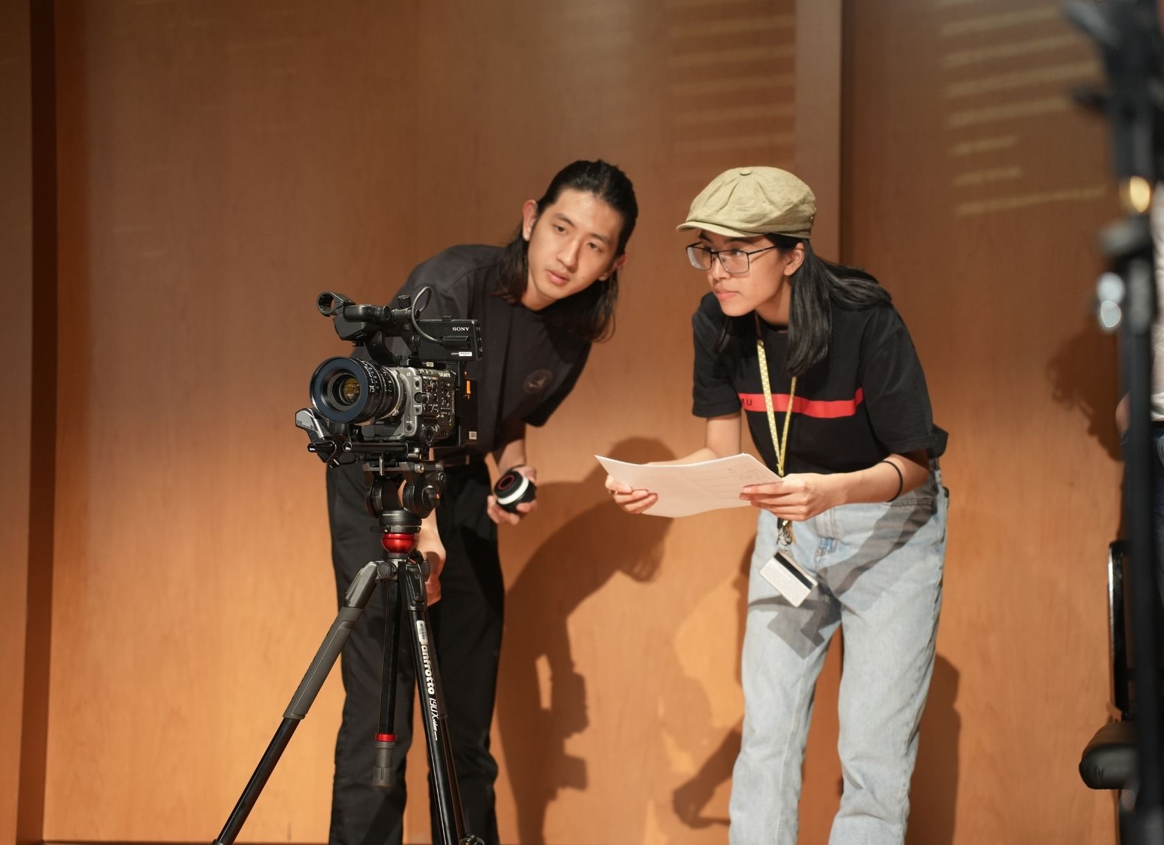 Isabel Li looks through a camera with a fellow student