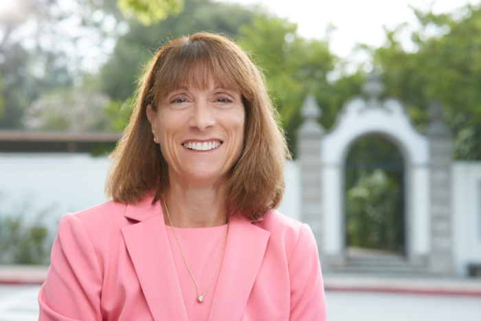 Portrait of President Amy Marcus-Newhall in front of Honnold Gate at Scripps College