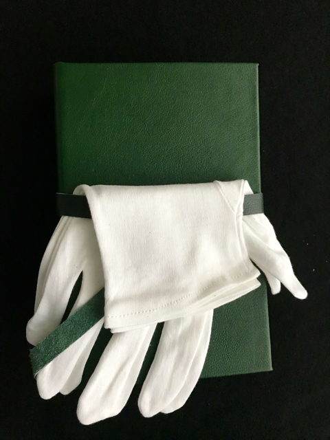 an image of a green goatskin leather book and white gloves