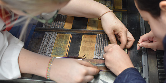 A close-up of hands crafting a book.