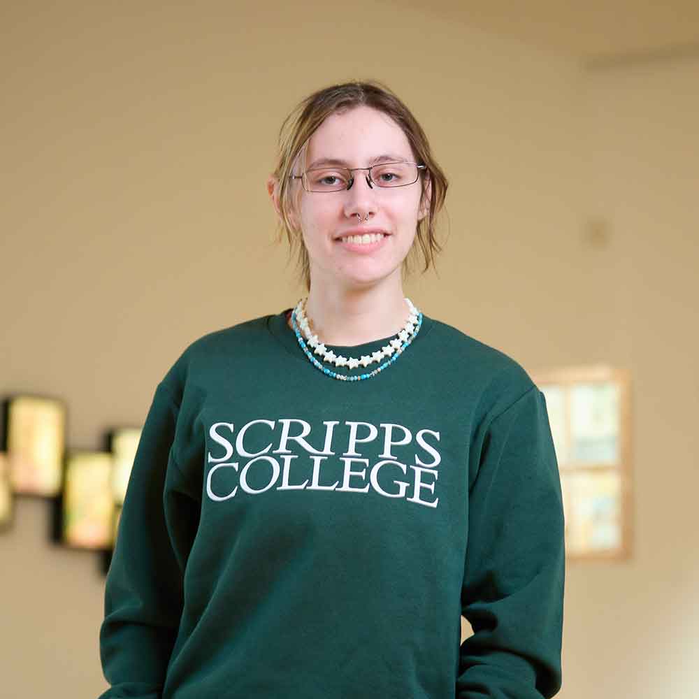A student wearing a Scripps College crew neck inside the gallery