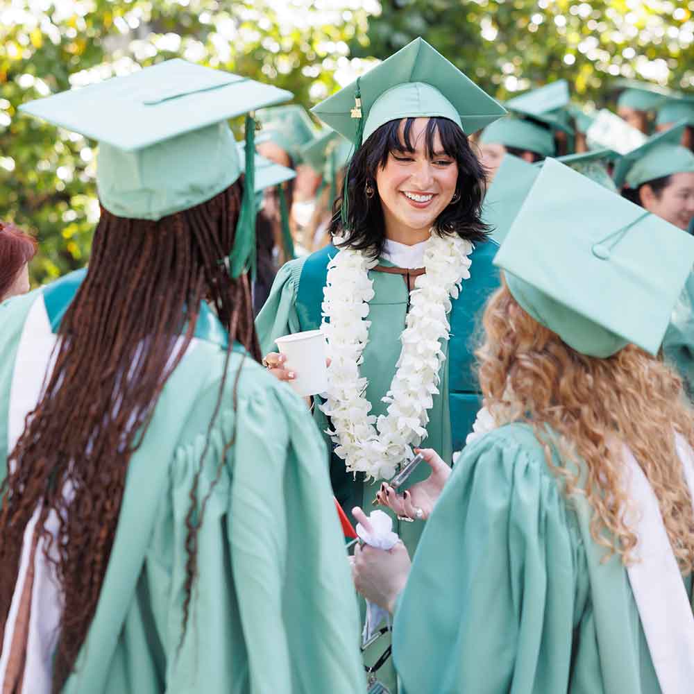 Three graduates talking after Commencement