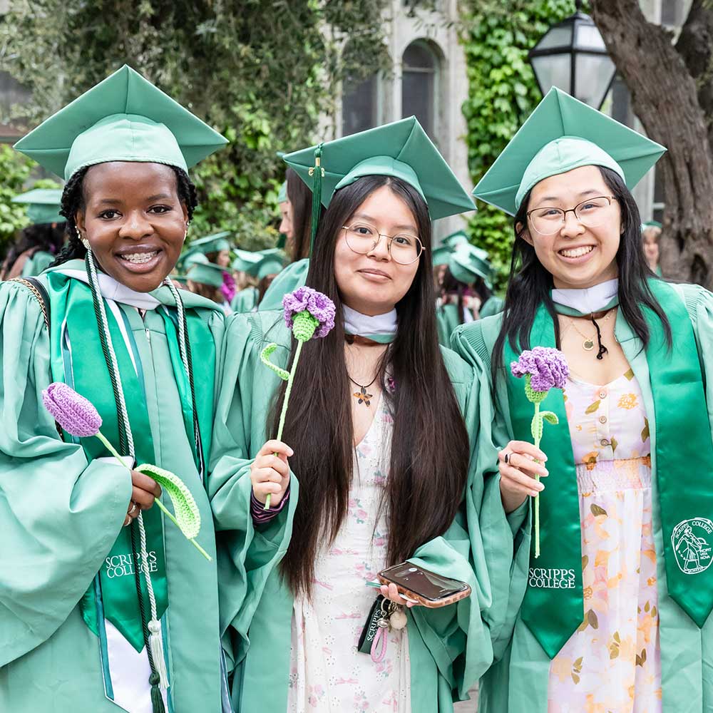 Three student smiling at Commencement
