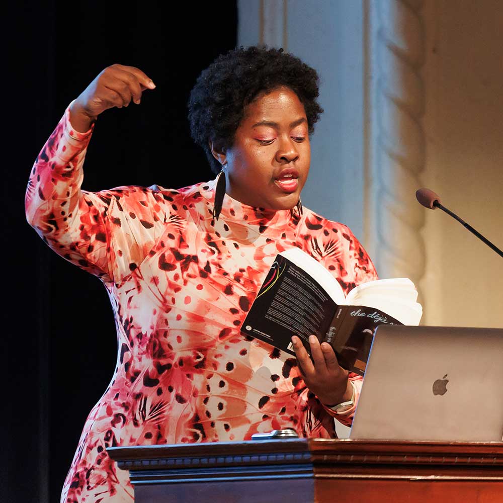 Speaker at a podium with a book